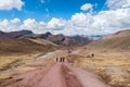 Tourists trekking on the red rocky road in Rainbow Mountains, Peru. Royalty Free Stock Photo