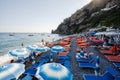 Tourists on Tyrrhenian sea, Amalfi coast, sunbed with umbrellas in beach Positano, Italy Royalty Free Stock Photo