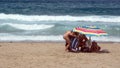 Tourists under a colorful umbrella