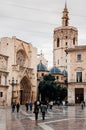 Tourists at Valencia Cathedral square with church and bell tower in background