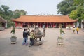 Tourists view ancient bronze incense burner at the Temple of Literature. Hanoi, Vietnam