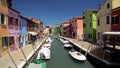 Tourists viewing brightly colored houses in Burano island street, Venice