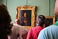 Tourists viewing a famous Rembrandt art work in the Hermitage museum.