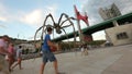 Tourists viewing huge Maman spider sculpture, sightseeing tour around Bilbao