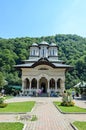 Tourists visit the old Lainici Monastery on a summer`s day, detail from the courtyard with exterior paintings