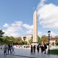 Tourists visiting ancient Egyptian Obelisk of Pharaoh Thutmose III, or Sultanahmet Square, Istanbul, Turkey