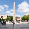 Tourists visiting ancient Egyptian Obelisk of Pharaoh Thutmose III, or Sultanahmet Square, Istanbul, Turkey