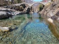 Tourists visiting the famous roman bridge of Lavertezzo on Verzasca valley on the italian part of Switzerland Royalty Free Stock Photo