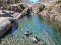 Tourists visiting the famous roman bridge of Lavertezzo on Verzasca valley on the italian part of Switzerland Royalty Free Stock Photo