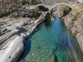 Tourists visiting the famous roman bridge of Lavertezzo on Verzasca valley on the italian part of Switzerland Royalty Free Stock Photo