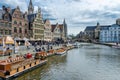 Tourists visiting historical center of Gent with medieval buildings overlooking the `Graslei harbor` on Leie river in Ghent town.