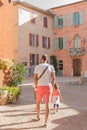 Tourists visiting the main square of Roussillon, a beautiful town whose buildings are painted in pastel and ocher colors