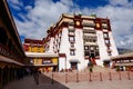 Tourists visiting Potala Palace walk around the beautiful courtyard on sunny day