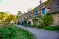 Tourists visiting stone cottages called Arlington Row at the Bibury village in Cotswold, Gloucestershire, England, UK Royalty Free Stock Photo