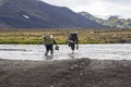 Tourists Wade the Stormy mountain river in Iceland Royalty Free Stock Photo