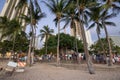 Tourists waiting street show surrounding Banyan tree in Waikiki beach