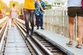 Tourists walk across across rail train tracks from side to another side while visiting The Bridge Over the River Kwai in Royalty Free Stock Photo