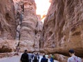 Tourists walk along the deep red canyon in the ancient capital of Jordan, Petra