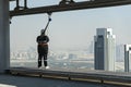 tourists walk along the edge of the roof of a skyscraper on the Sky View skyscraper. Dangerous scary attraction.