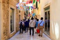 Tourists walk along the old town in Sibenik, Croatia. People go sightseeing in the historical center of the Croatian city