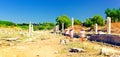 Tourists walk along remaining ruins of ancient antique road in Side