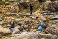Tourists walk along a rocky hill