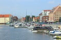 Tourists walk around beautiful touristic Polish city Gdansk along water canal Royalty Free Stock Photo