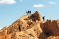 Tourists walk around Fairytale canyon or Skazka Canyon, Natural park of colorful rocks near Issyk-Kul lake, Kyrgyzstan.