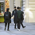 Tourists walk, back view. Two fashionable young men in black