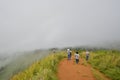 Tourists walk down in the fog to foothill