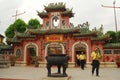 Tourists walk out old Chinese style gateway, Vietnam Royalty Free Stock Photo