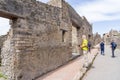 Tourists walk among the remains of one of the main streets of the ruined city of Pompeii, Italy