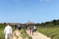 Tourists walk on the sand near the Rubjerg Knude Lighthouse on the coast of the North Sea in the Jutland in northern