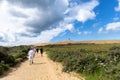 Tourists walk on the sand near the Rubjerg Knude Lighthouse on the coast of the North Sea in the Jutland in northern