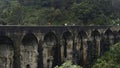 Tourists walk on stone bridge in jungle. Action. People walk on ancient stone bridge in rainforest. Beautiful landscape Royalty Free Stock Photo