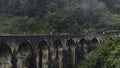 Tourists walk on stone bridge in jungle. Action. People walk on ancient stone bridge in rainforest. Beautiful landscape Royalty Free Stock Photo