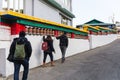 Tourists walk and swipe Tibetan prayer wheel in area of Rumtek Monastery near Gangtok. Sikkim, India