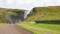 Tourists walk to Skogafoss waterfall in Iceland Royalty Free Stock Photo