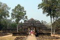 Tourists walk towards the Baphuon temple in Angkor Thom