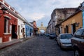 Tourists walking along the cobbled streets and along the Gate `Arco de Santa Catalina` of the colonial town Antigua, Guatemala Royalty Free Stock Photo