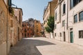 Tourists are walking along the narrow and bright streets of sunny Venice, Italy