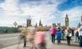 Tourists walking along Westminster Bridge in London. Long exposure shot