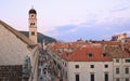 Tourists walking on ancient Stradun street in old city in Dubrovnik at sunset, purple sky background, Croatia