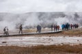 Tourists walking on boardwalk on swamp area of geyser basin