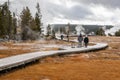 Tourists walking on boardwalk on swamp area of geyser basin Royalty Free Stock Photo