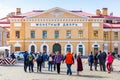 Tourists walking on courtyard with orange building in Peter and Paul Fortress