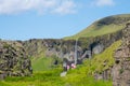 Tourists walking at Dverghamrar in south Iceland with waterfall Foss a Sidu in the background