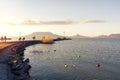 tourists walking on Fonyod pier at Lake Balaton winter spring time in the sunset Badacsony hill background Royalty Free Stock Photo