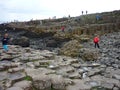 Tourists walking on Giant's Causeway's basalt columns Royalty Free Stock Photo