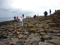 Tourists walking on Giant's Causeway's basalt columns Royalty Free Stock Photo